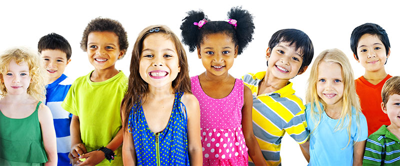 A group of children posing together with smiles, wearing colorful clothing against a white background.