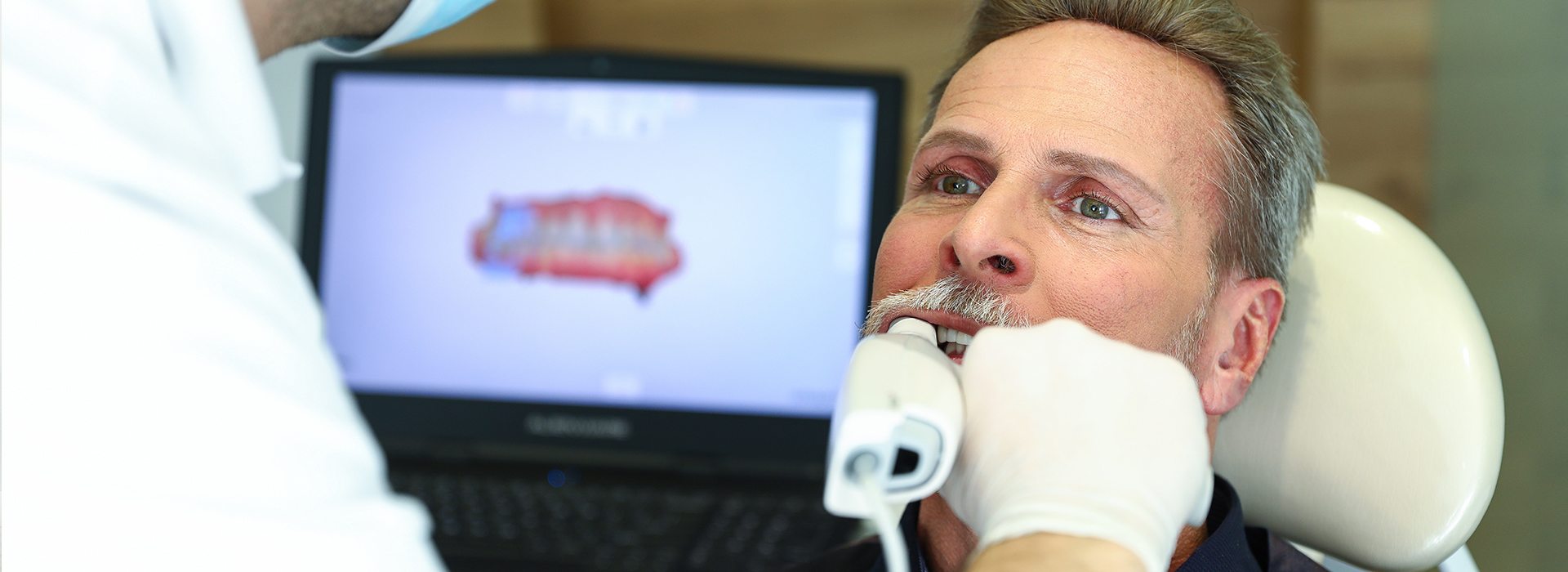 A person receiving dental care with a dentist using specialized equipment.